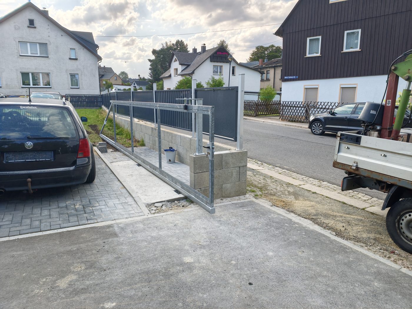 Verzinktes Schiebetor an einer Einfahrt, die Montage ist in Arbeit